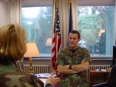 Man in military uniform standing in office with arms crossed