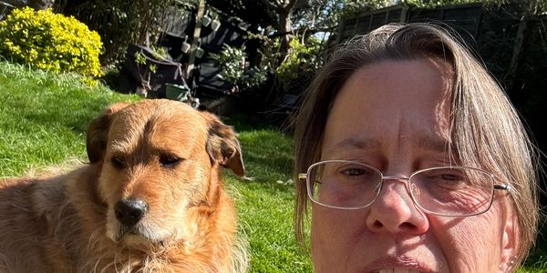 Ange sat in a garden with a reactive dog