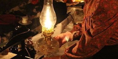 A historical interpreter heats a gas lamp during the annual Friends of the Library and Museum's Holiday's Eve at the Littleton Historical Museum. 