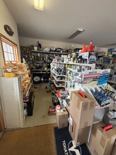 A cluttered store aisle filled with automotive supplies and snacks.