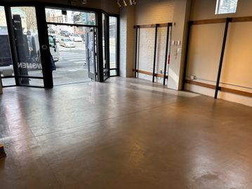 Empty commercial space with large windows and polished concrete floor.