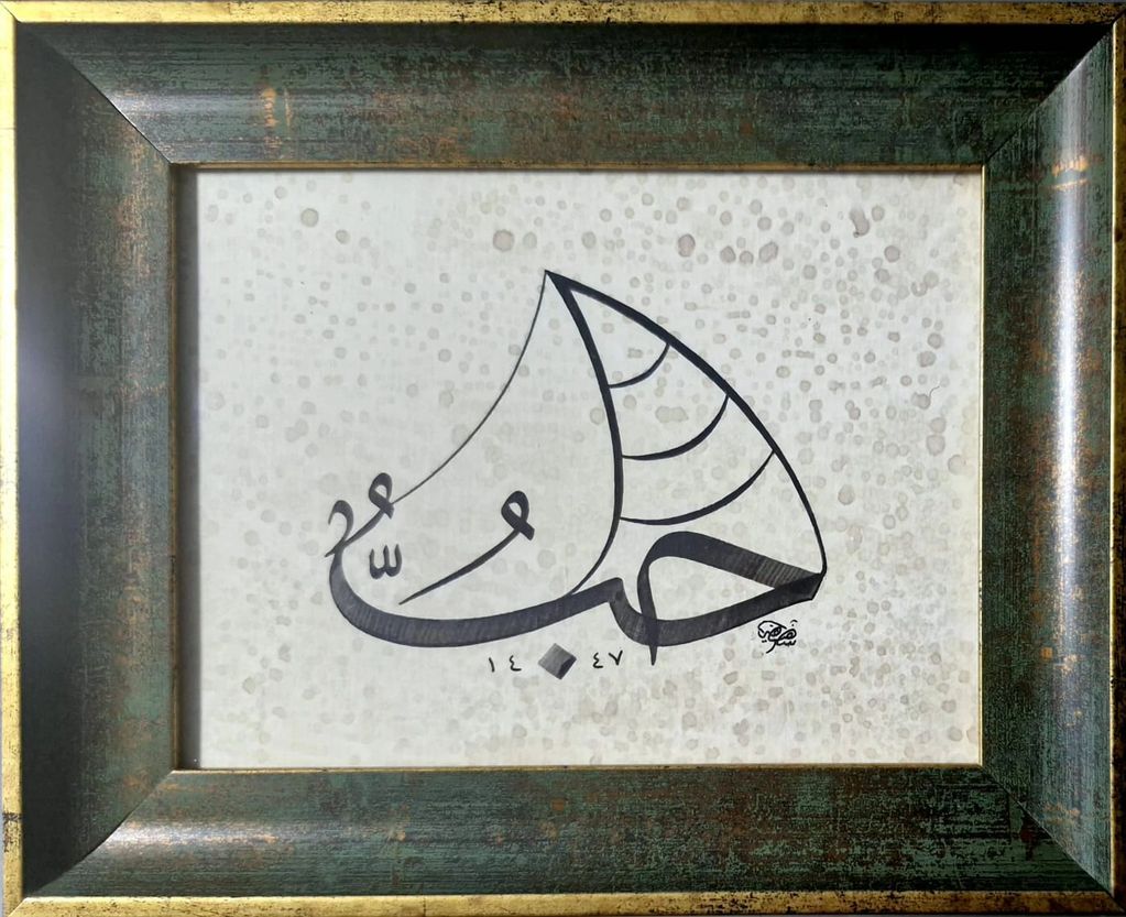 Framed Arabic calligraphy artwork with decorative dots on a textured background.