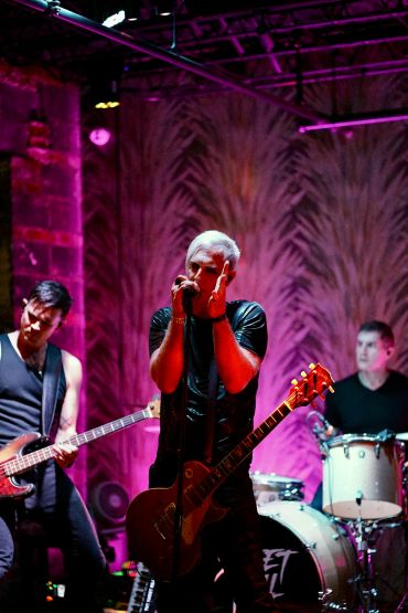 Band performing live on stage with vibrant lighting.