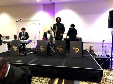 Band performing on stage at an indoor event.