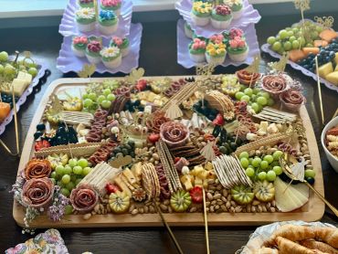 Elegant charcuterie board with meats, cheeses, fruits, and crackers.