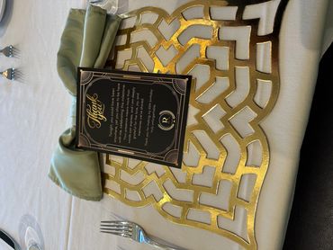 Elegant table setting with a thank you card and gold-accented placemat.