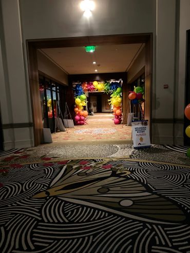 Colorful balloon arch at a hallway entrance.