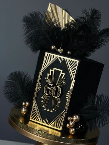 Elegant black and gold decorative piece with feathers.