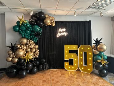 50th birthday party setup with balloons and lights.