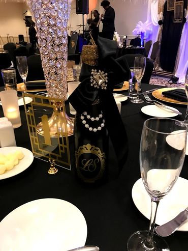 Elegant table setting with decorated champagne bottle.