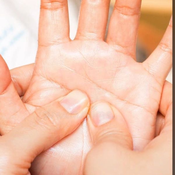 Close-up of thumb pressing the palm of a hand.