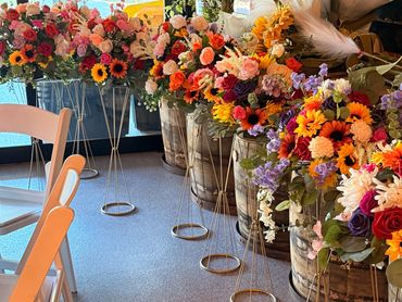 Colorful flower arrangements in vases lined up indoors.