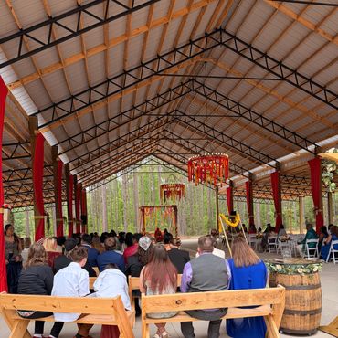Guests seated in a decorated pavilion for a ceremony.