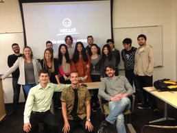 a group of students standing near a projector 