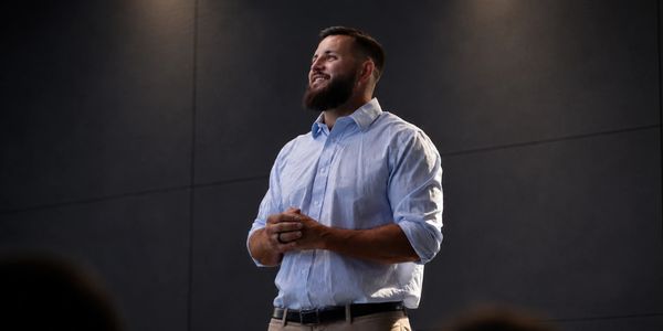 Man in a light blue shirt speaking confidently.