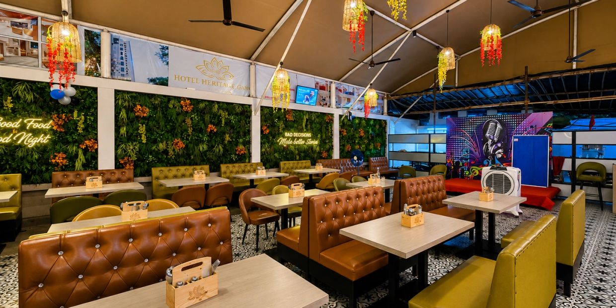 Modern and cozy restaurant seating with greenery walls and warm lighting.