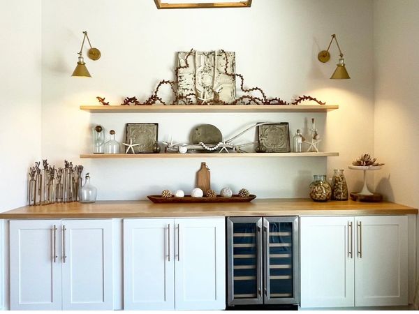 Minimalist display with shelves, decor, and cabinet with wine cooler.