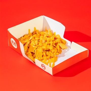 Cheesy fries in a branded red and white box on a red background.