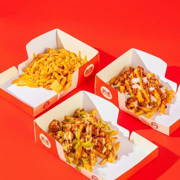 Three servings of loaded fries with various toppings in Joe Burger boxes.
