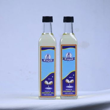 Two bottles of Royal premium coconut oil with blue labels on a white surface.