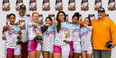 Girls soccer team posing with trophies after winning a championship.