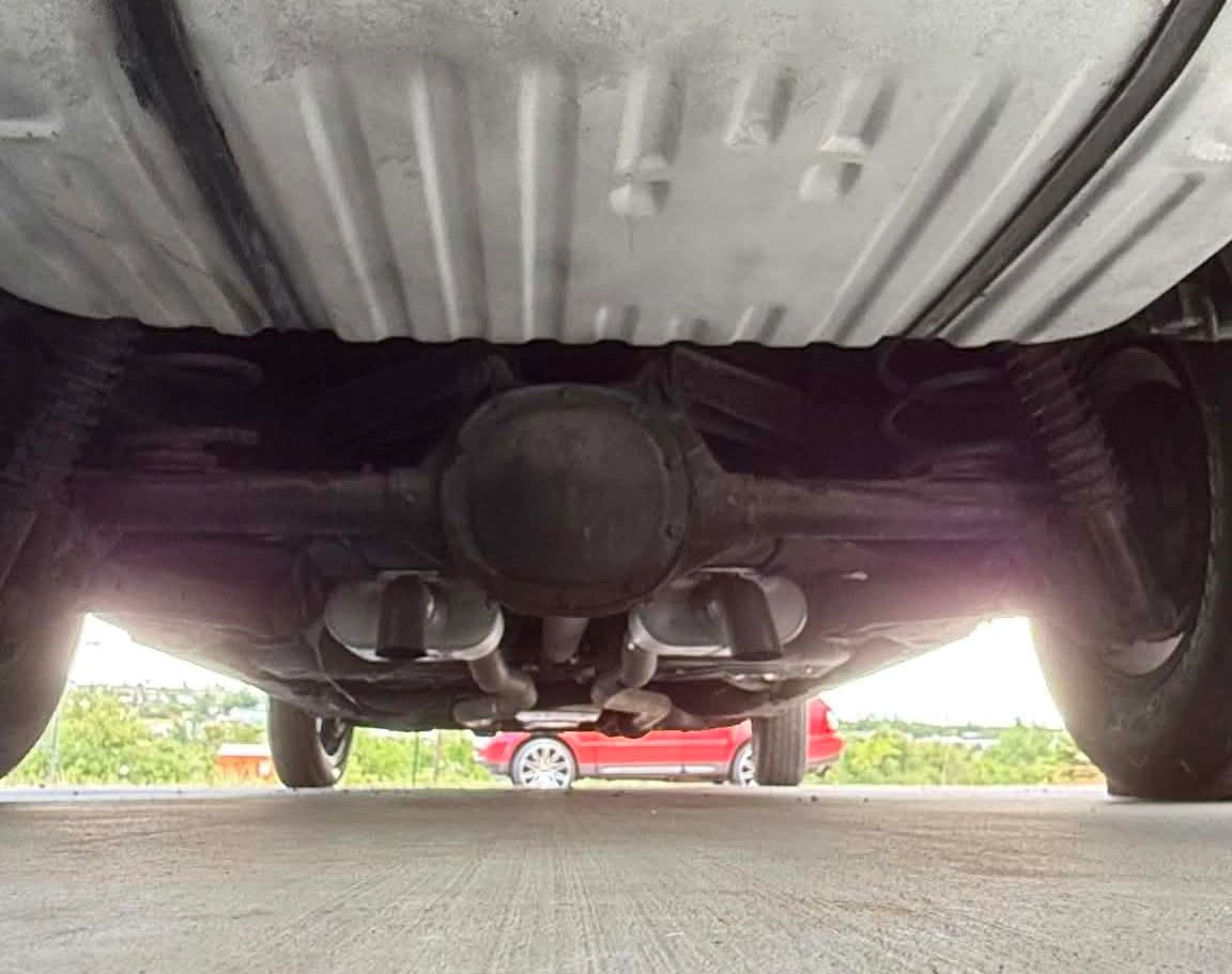 Underside view of a vehicle showing suspension and exhaust system.