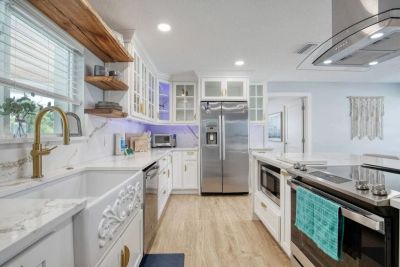 Modern white kitchen with stainless steel appliances.