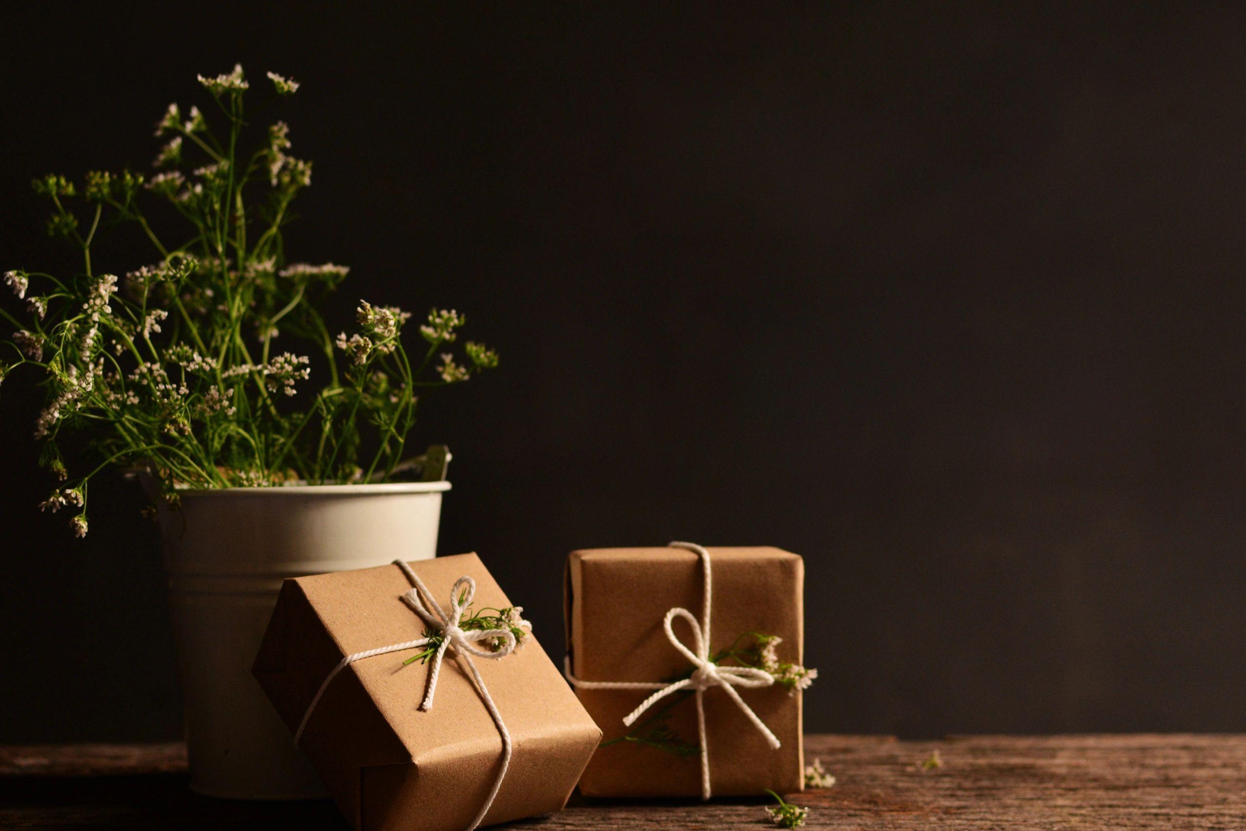 Simple gifts wrapped in brown paper with white twine and flowers.