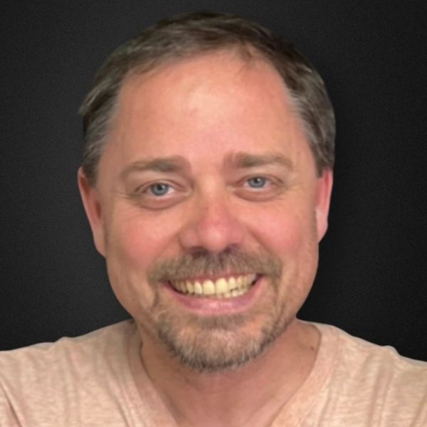 Smiling man with short hair and light beard.