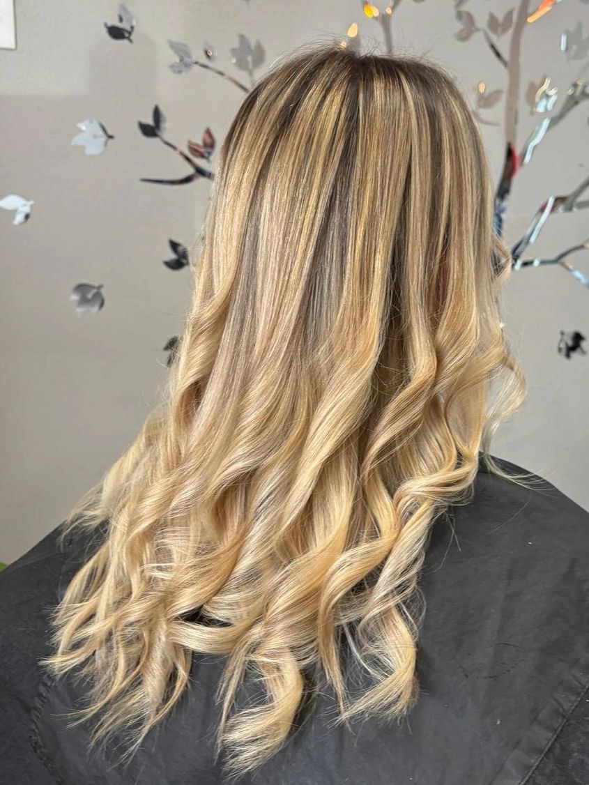 Long blonde hair with soft curls.