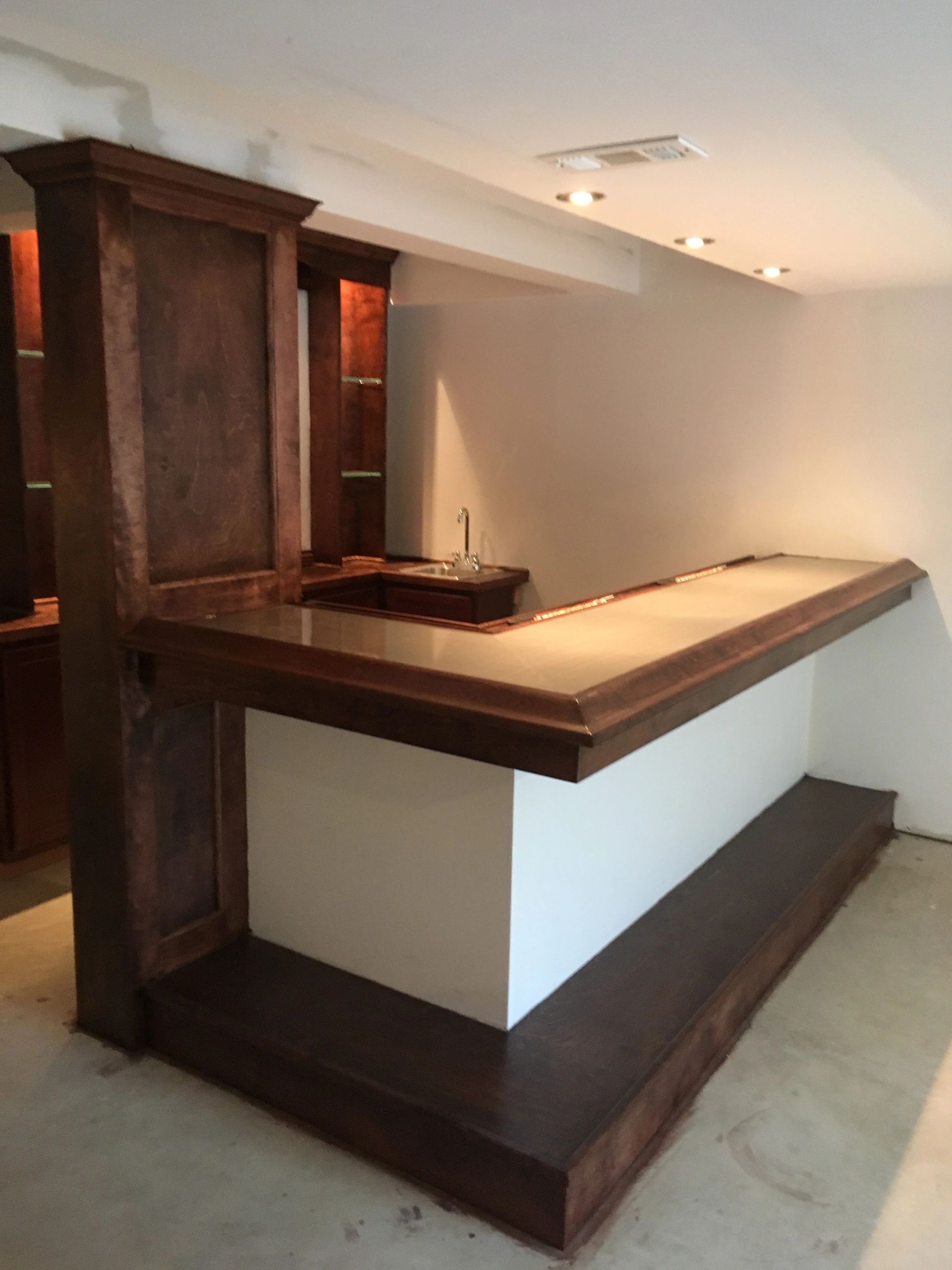 Wooden bar with a sink in a minimalist room.
