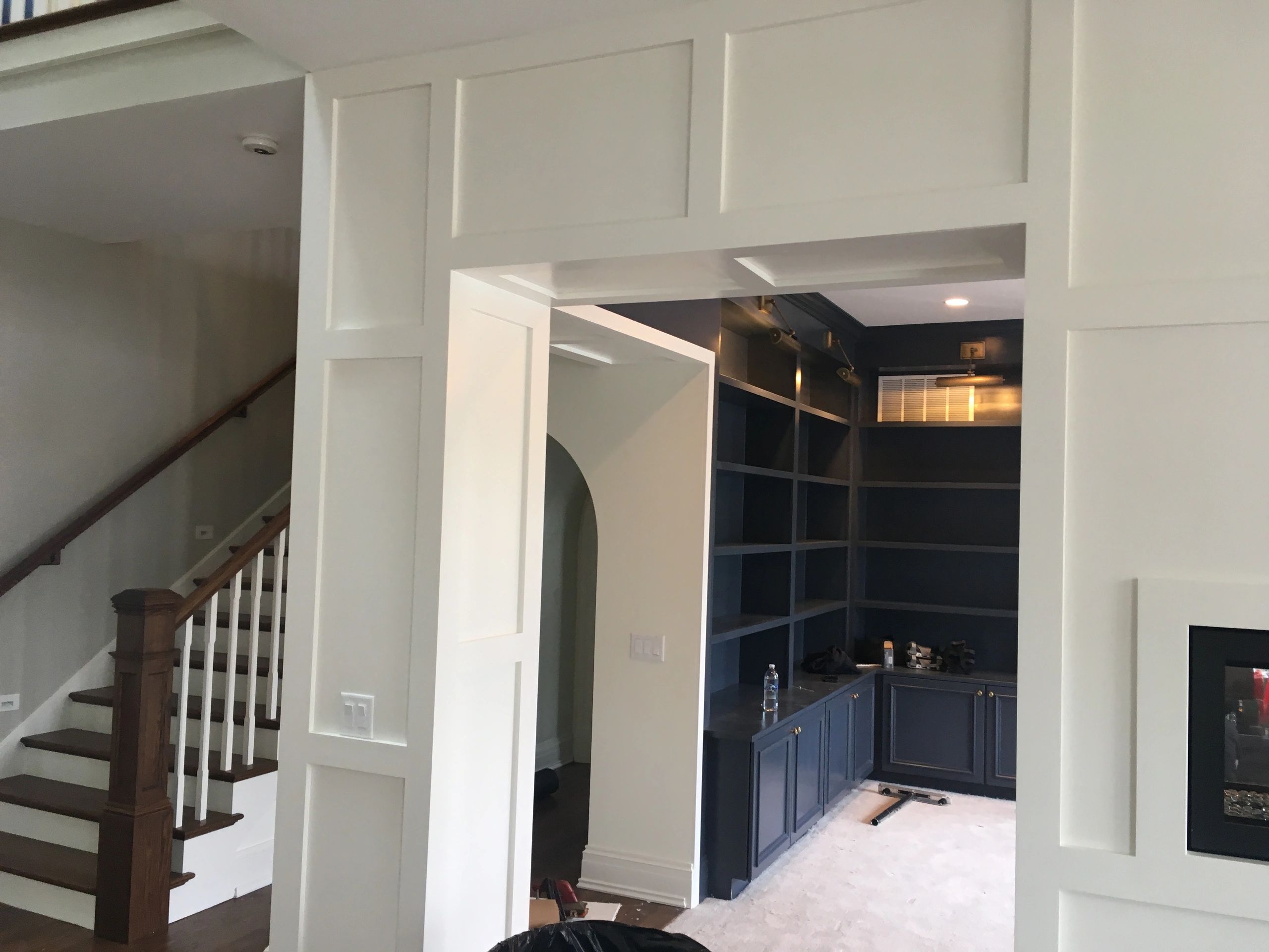 Interior view of a modern home with white paneled walls and dark blue built-in shelves.