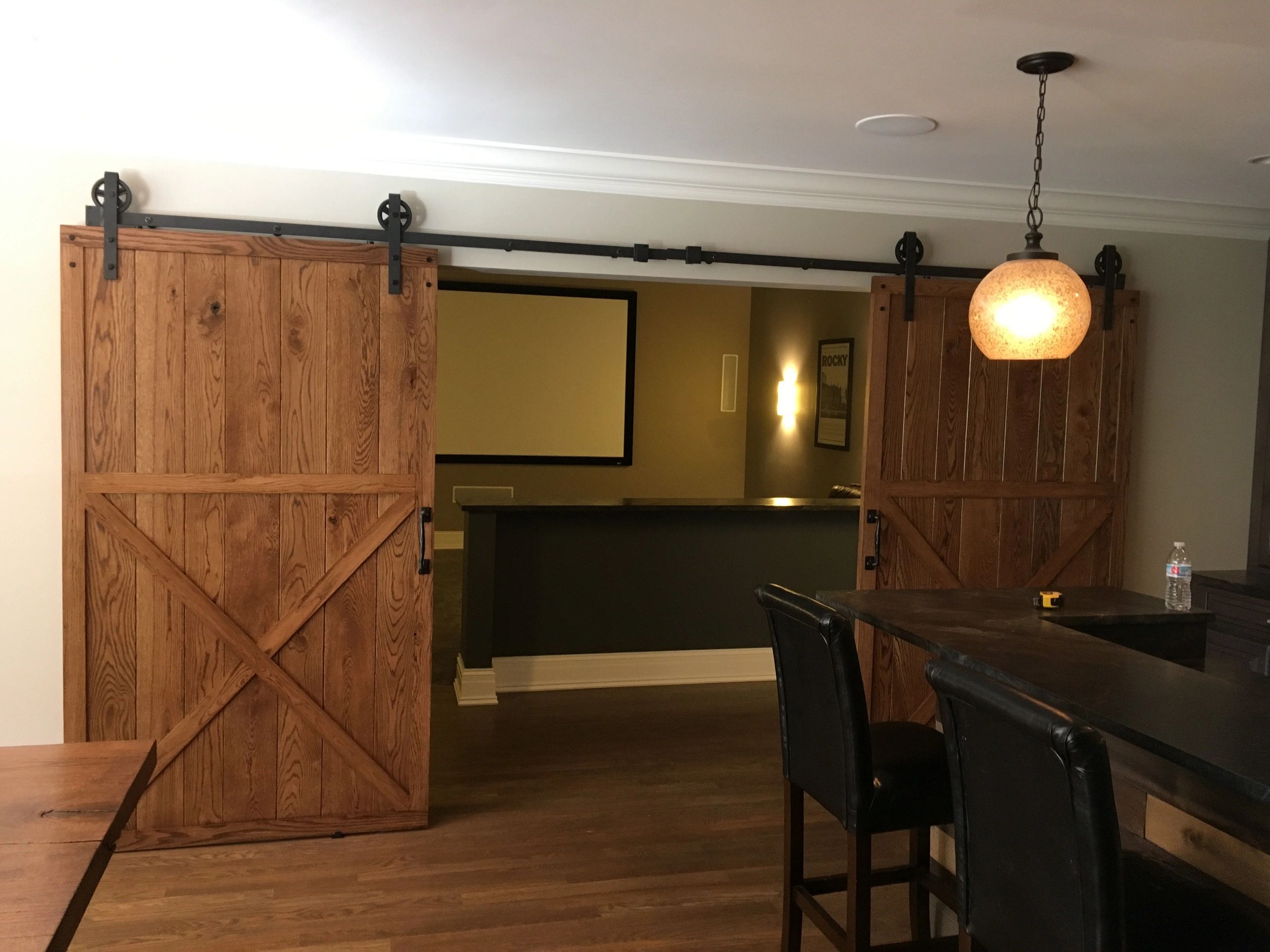 Rustic wooden sliding barn doors with black hardware in a cozy room.