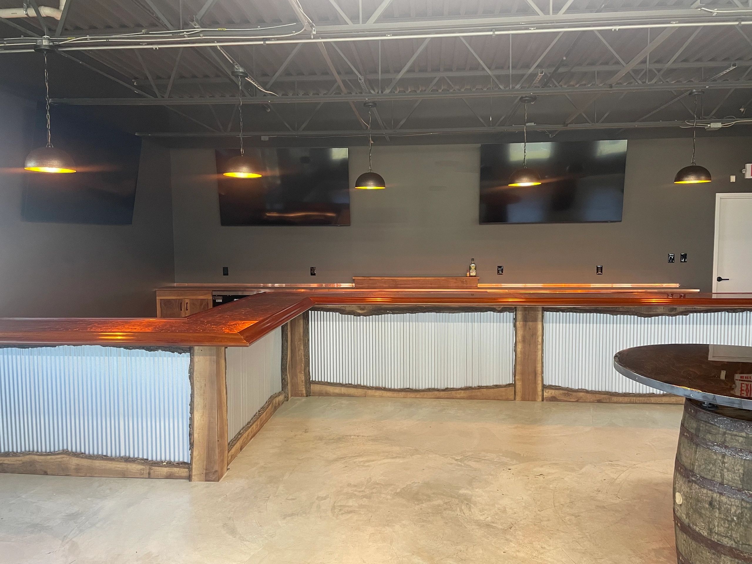 Rustic bar area with wooden countertops and hanging pendant lights.
