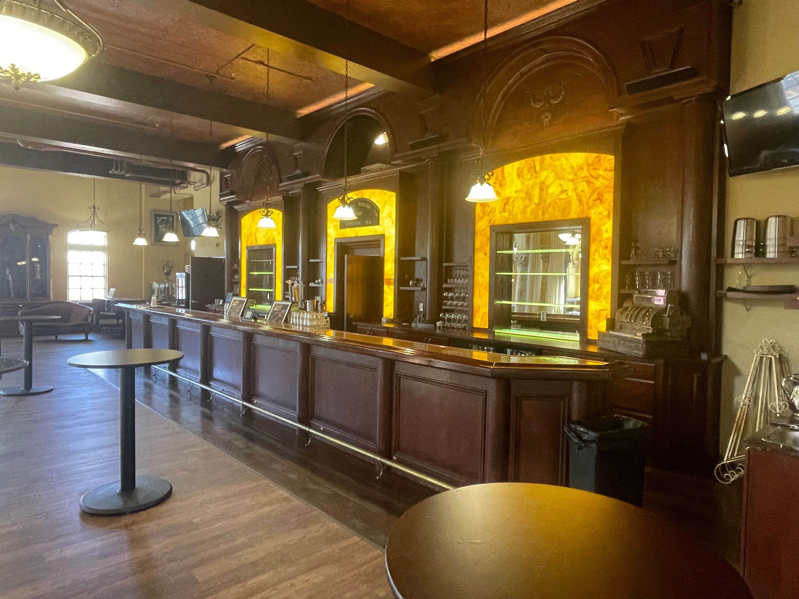 Elegant bar with wooden interiors and warm lighting.