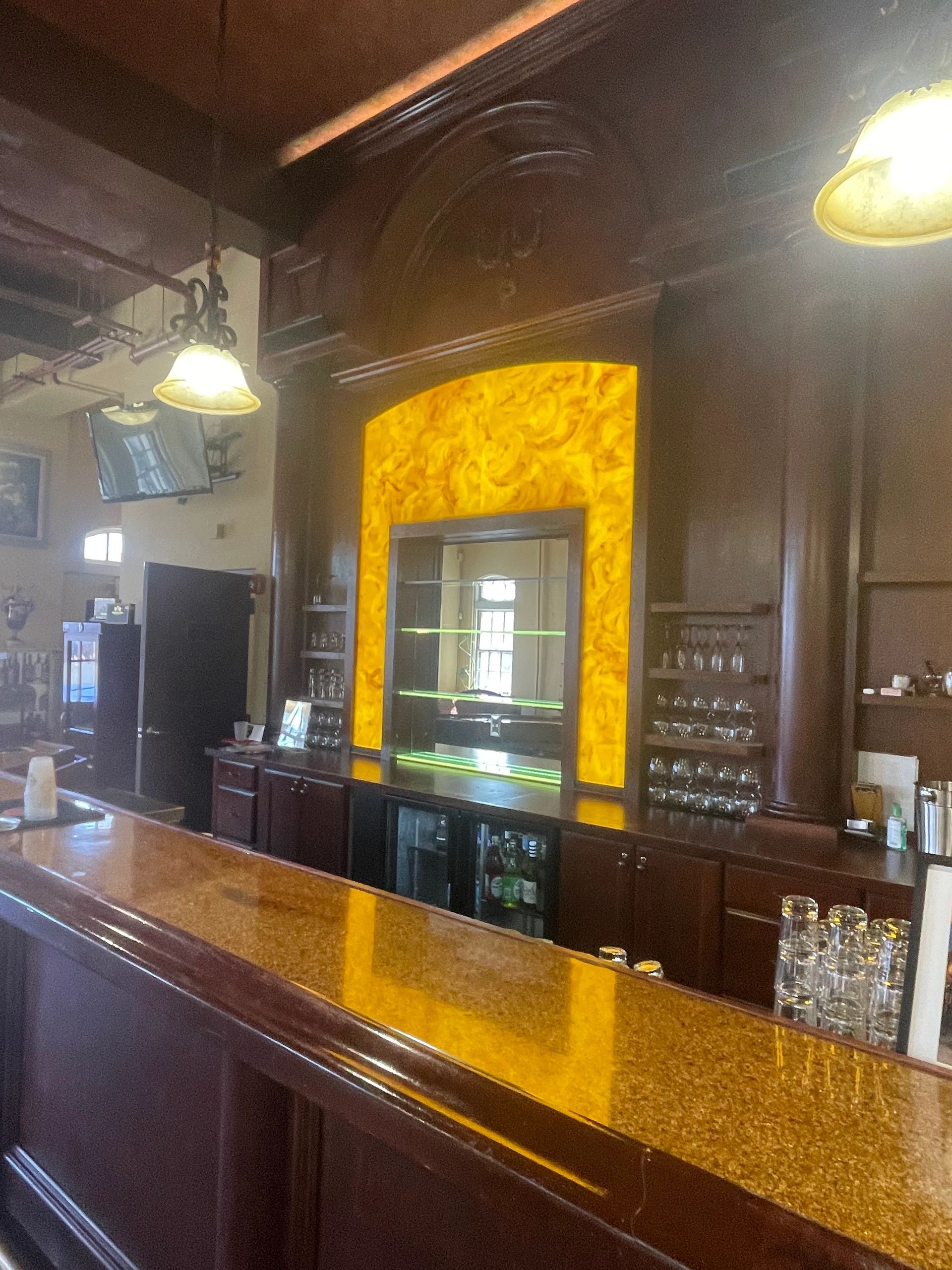 Vintage bar with illuminated amber feature and glass shelves.
