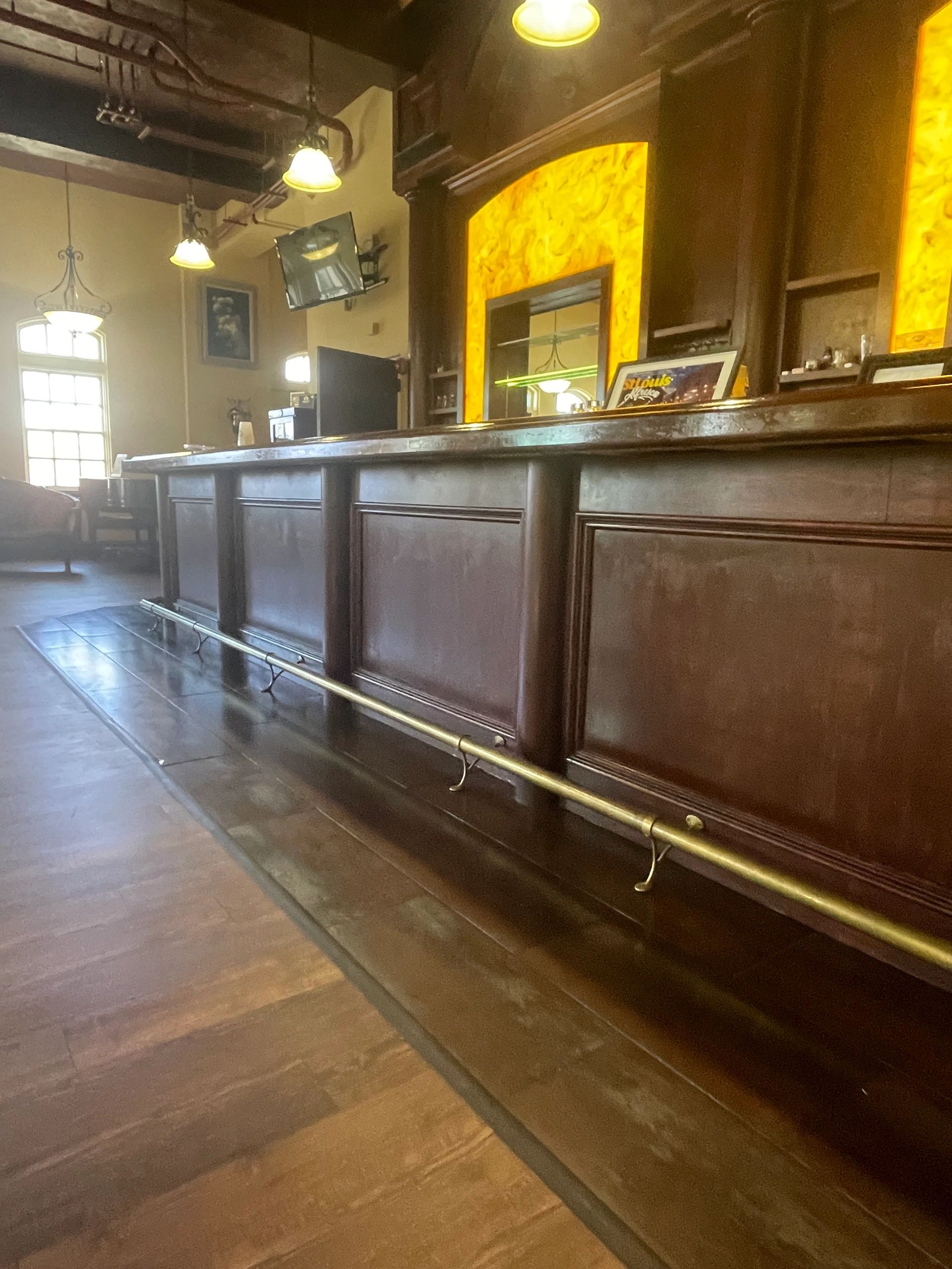 Empty wooden bar with yellow backlit panels and TV.