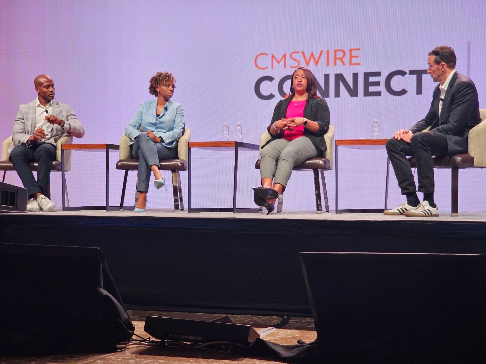 Four professionals engaged in a panel discussion at CMSWIRE CONNECT event.