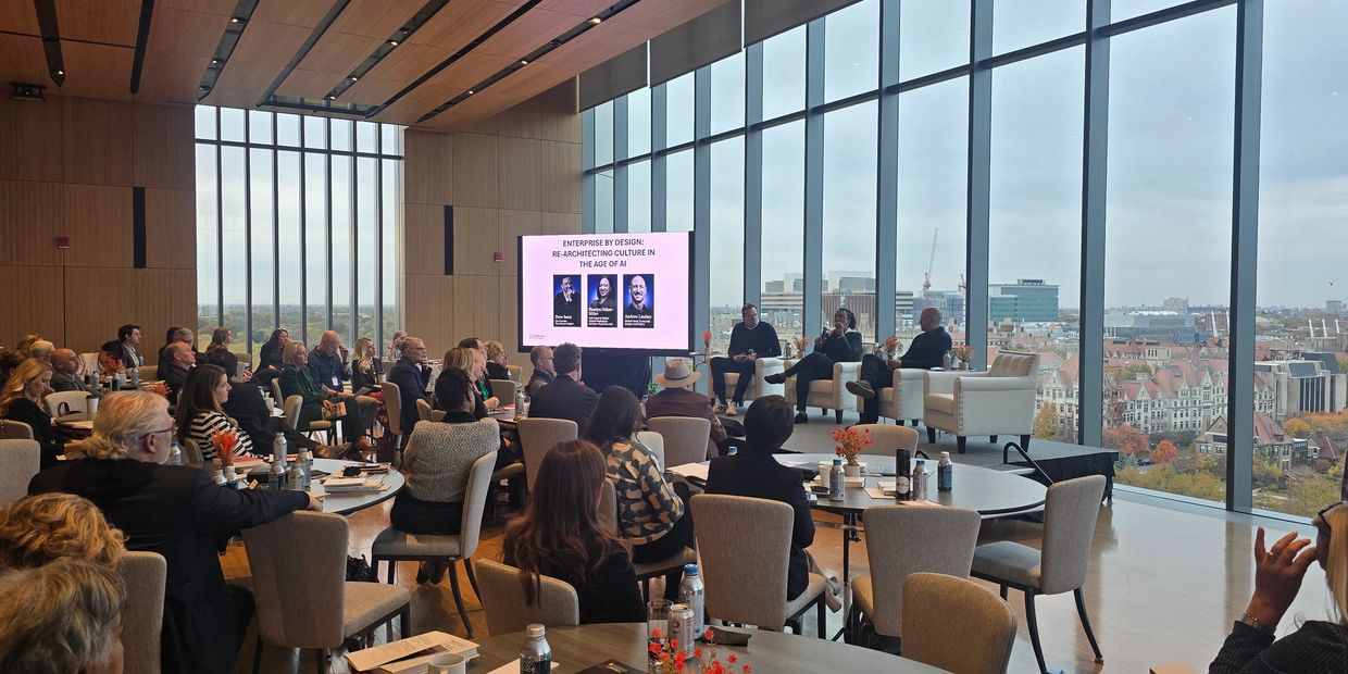 Panel discussion on AI culture in a modern conference room with city views.