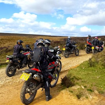 Adventure motorcycle riders exploring scenic green lanes during a guided off-road tour in the Peak District.