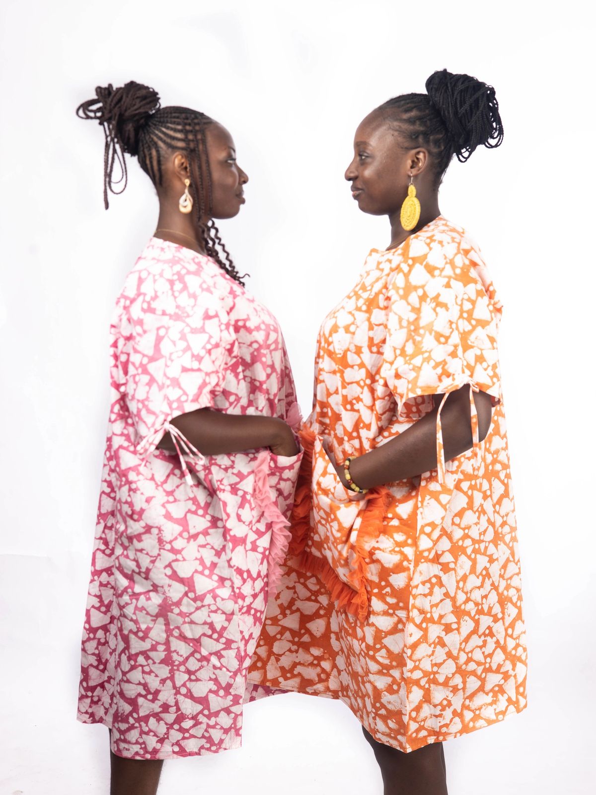 2 models wearing Adaora pink and orange Adire dresses
