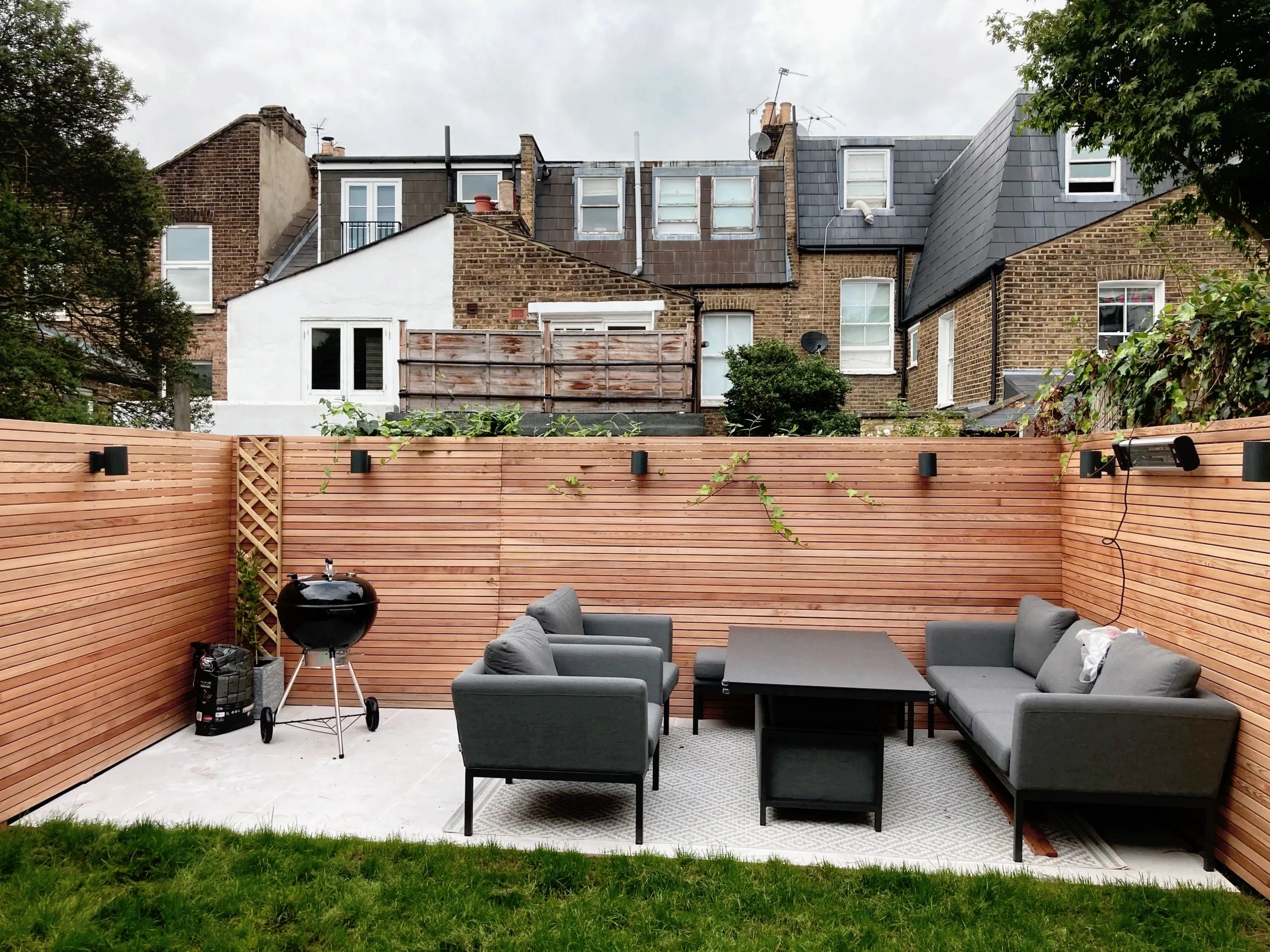 Cedar fencing with porcelain paving slabs and lawn