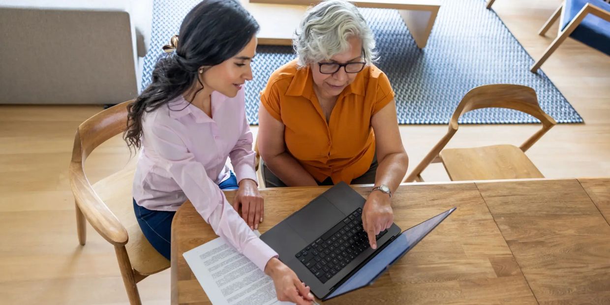Two women reviewing insurance on laptop