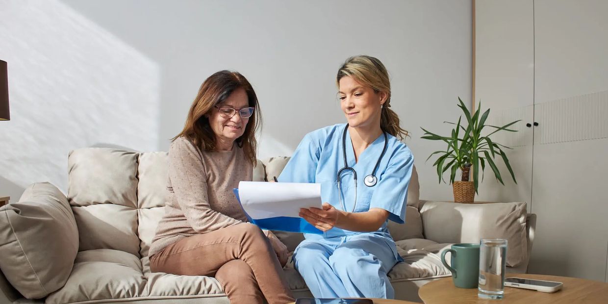 Nurse and senior woman looking at clipboard
