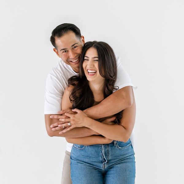 A man holding his wife in a big hug.