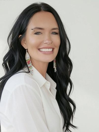 Smiling woman with long black hair and earrings.