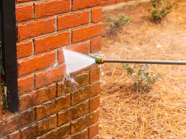 Power washing a brick wall