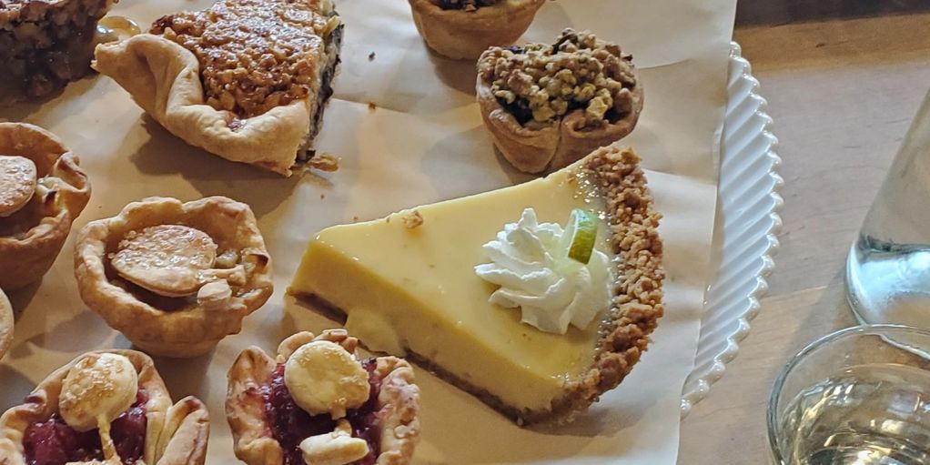 Assorted mini pies and a slice of key lime pie with whipped cream.