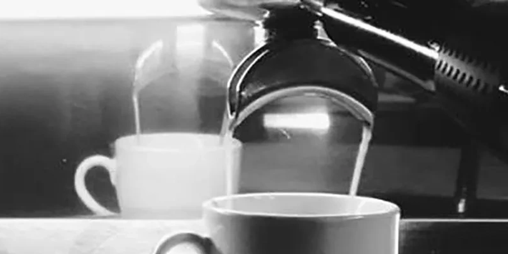 Pouring hot coffee into a cup in a cozy setting.