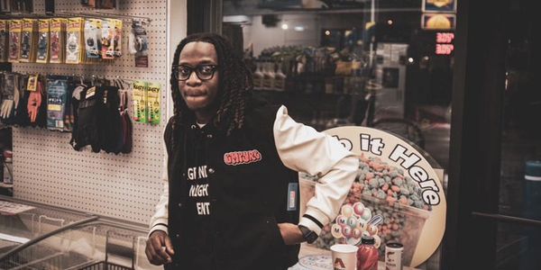A person stands inside a store with snacks and drinks nearby.